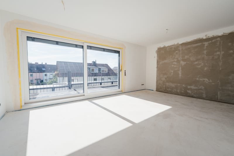 Wohnraum mit Glasschiebetür und Blick über die Dächer